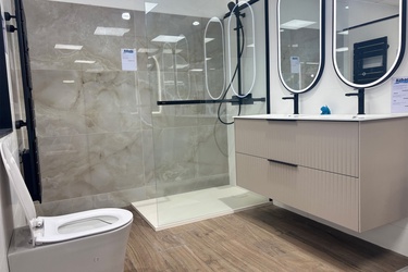 Salle de bain avec douche, sèche serviette, toilette et meuble suspendu double vasque