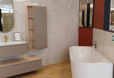 Salle de bain avec baignoire, meuble suspendu et colonne de rangement